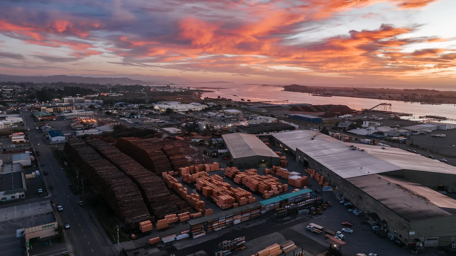 Working lumber yard on Humboldt Bay at sunset, commercial drone aerial by Tex Kelly Productions