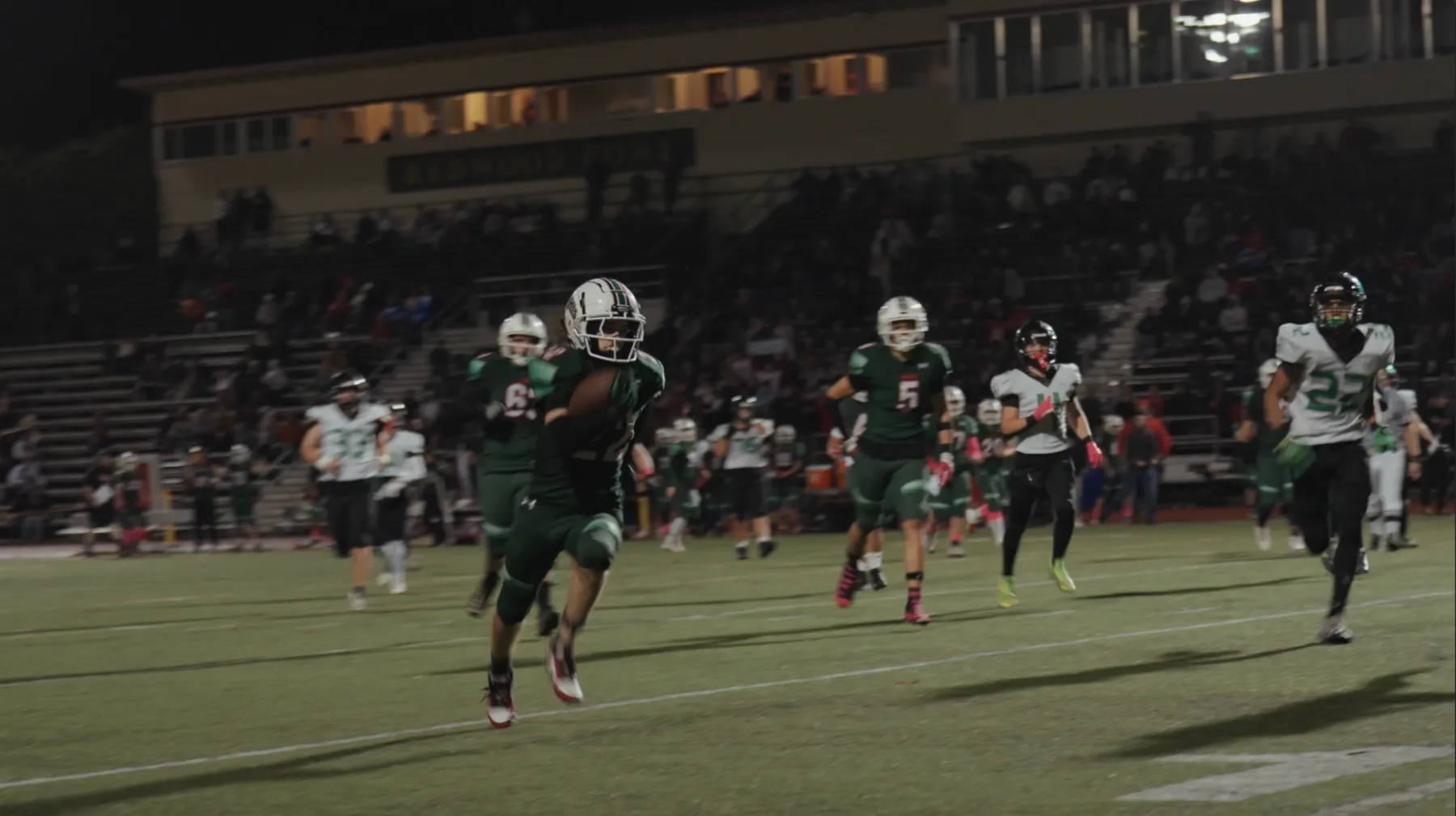Frame from a Humboldt County football highlight reel under stadium lights